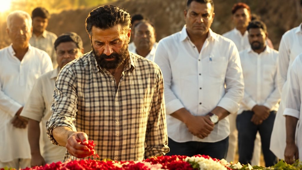 Suryaa फिल्म के सीन में Sunny Deol फूलों से भरी जगह पर खड़े हैं और पीछे सफेद कपड़ों में कई लोग नजर आ रहे हैं।
